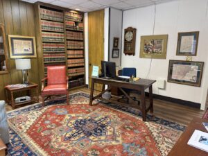 Kendall Page Office Desk Area Attorney desk area with red leather chair and law book library at Kendall Page office